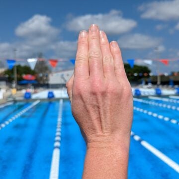 A swimmer demonstrates a tight hand position for swimming