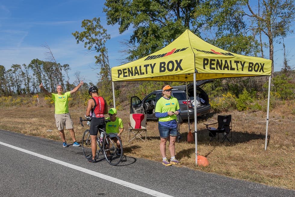 Image for Ironman Florida showing a penalty box with athletes waiting until an official says they can continue after breaking triathlon rules.