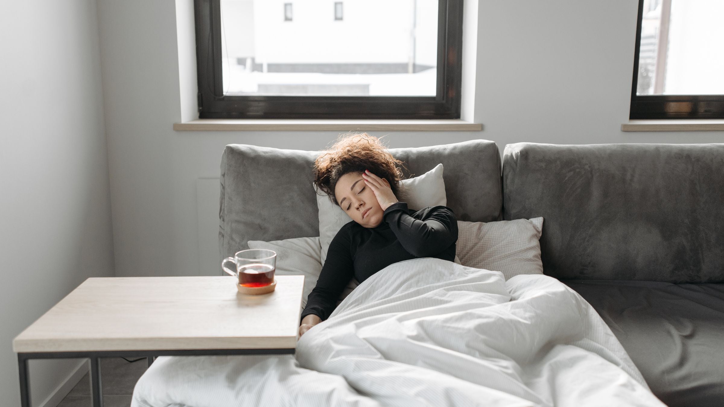 A woman lies in bed and wonders Why do I get sick after racing?