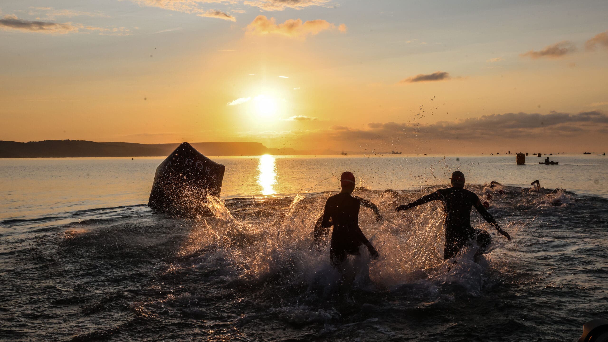 Athletes enter the water during the 70.3 triathlon.