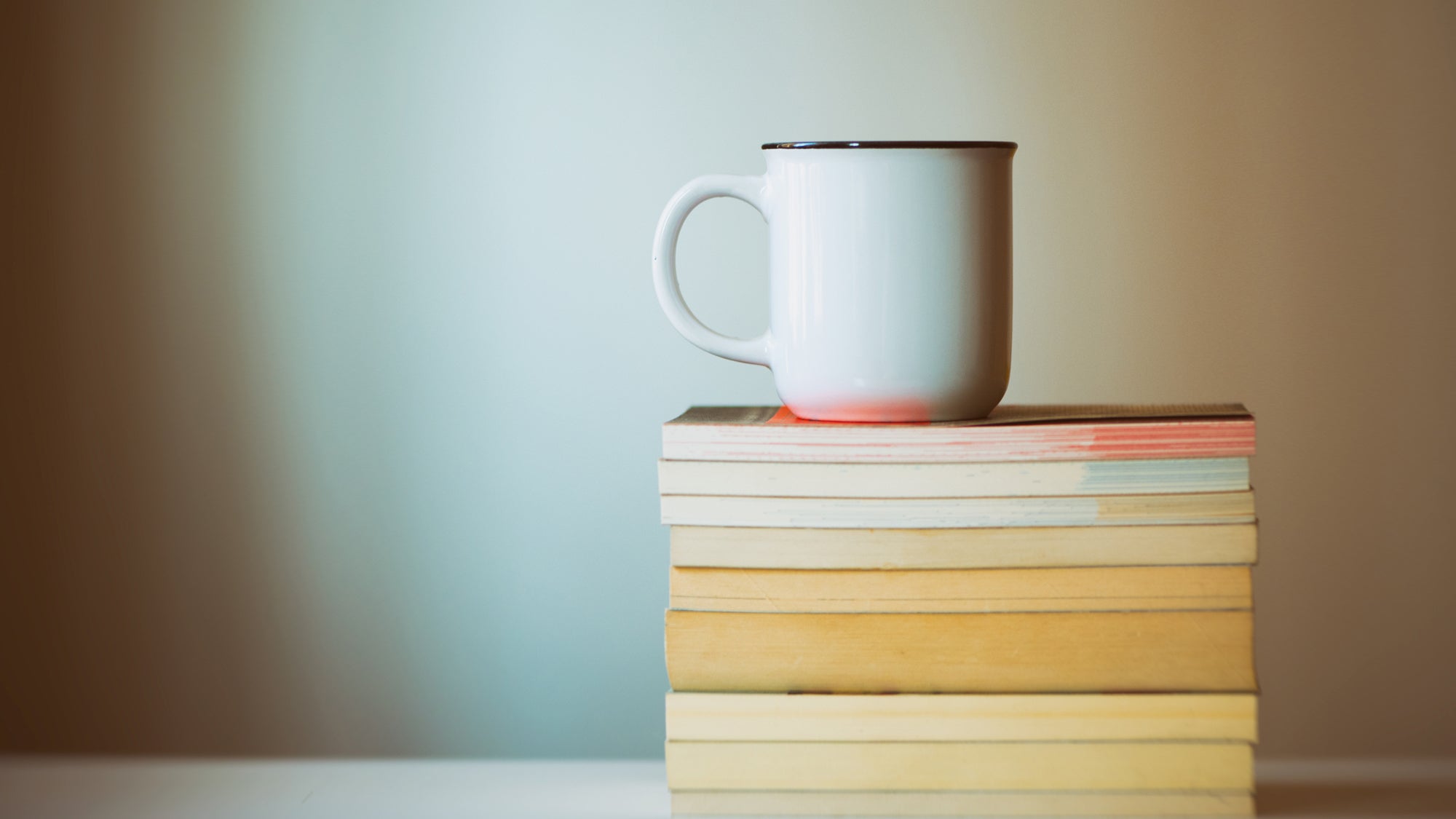 A cup of coffee on a stack of the best triathlon books.
