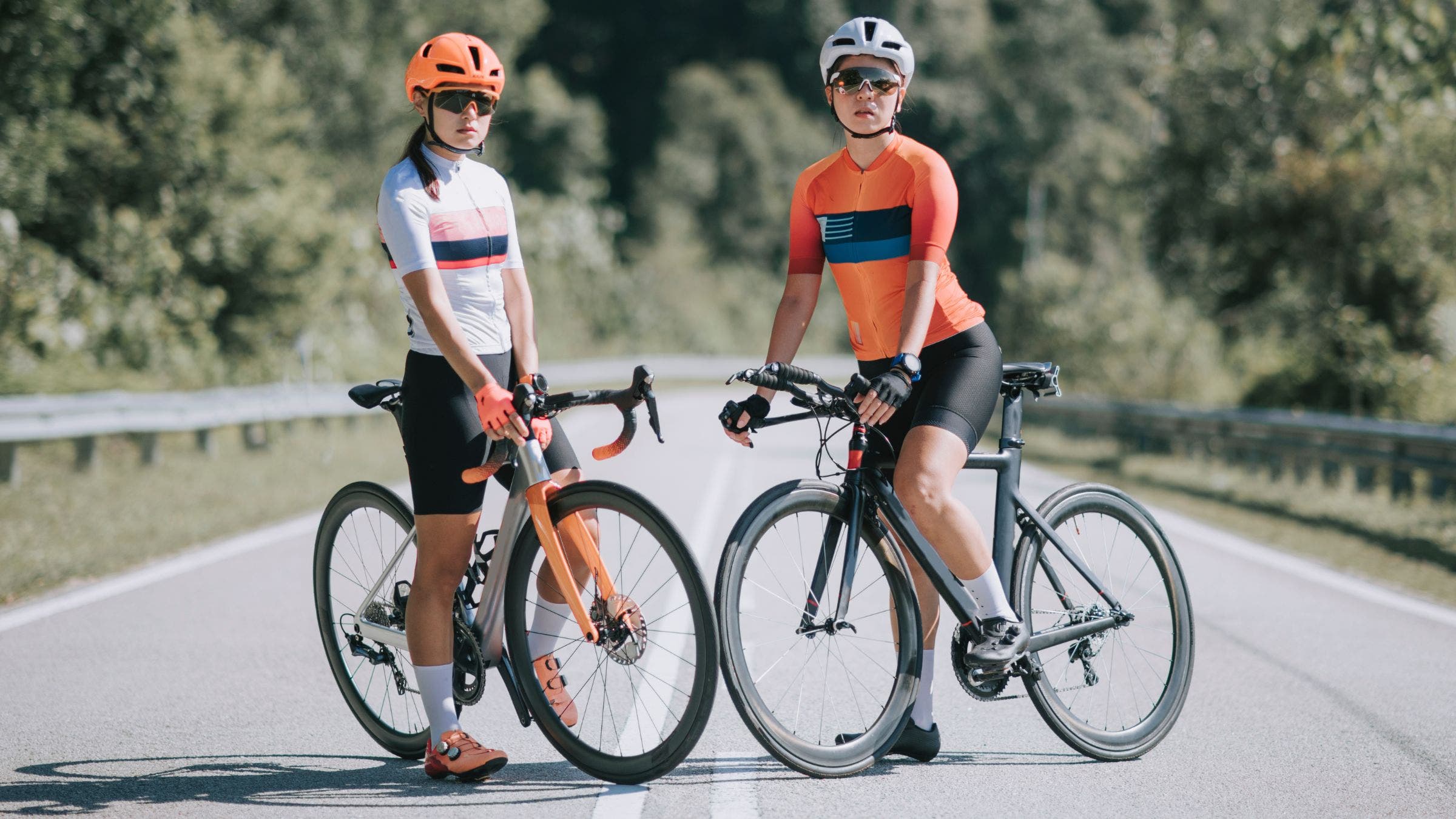 One woman rides a road bike vs. triathlon bike for another woman.
