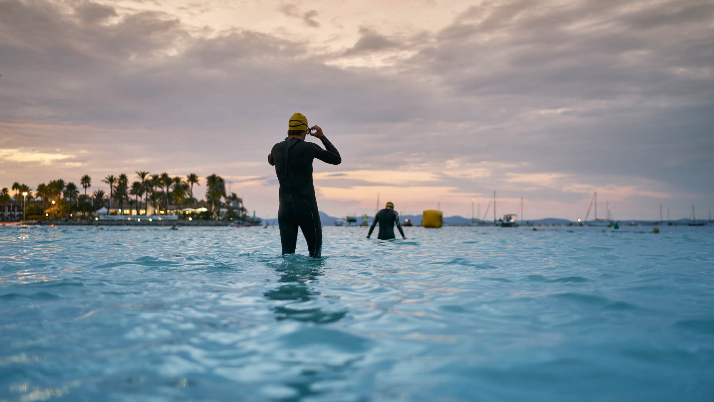 Rear view of people wearing wetsuits in ocean