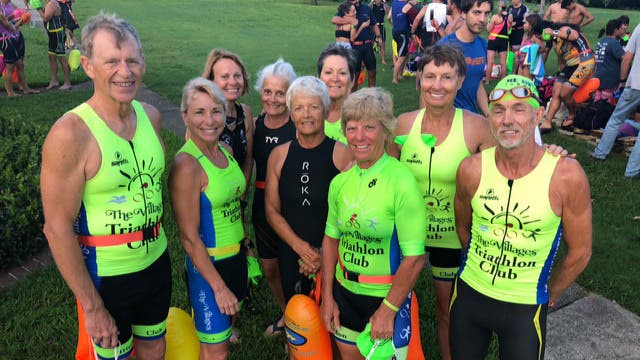 The Villages Triathlon Club poses at a triathlon.
