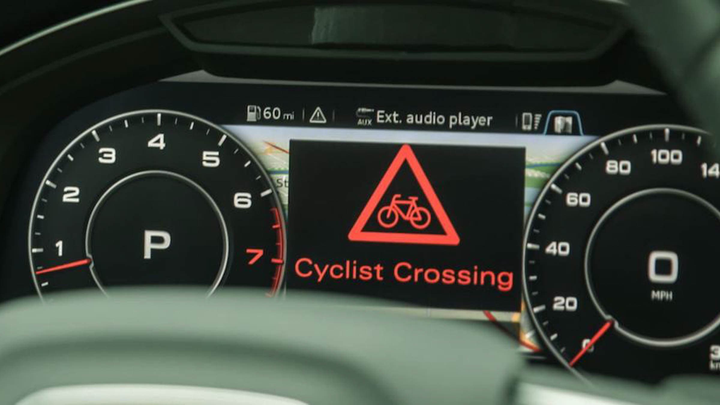 Car dashboard display with a "Cyclist Crossing" warning