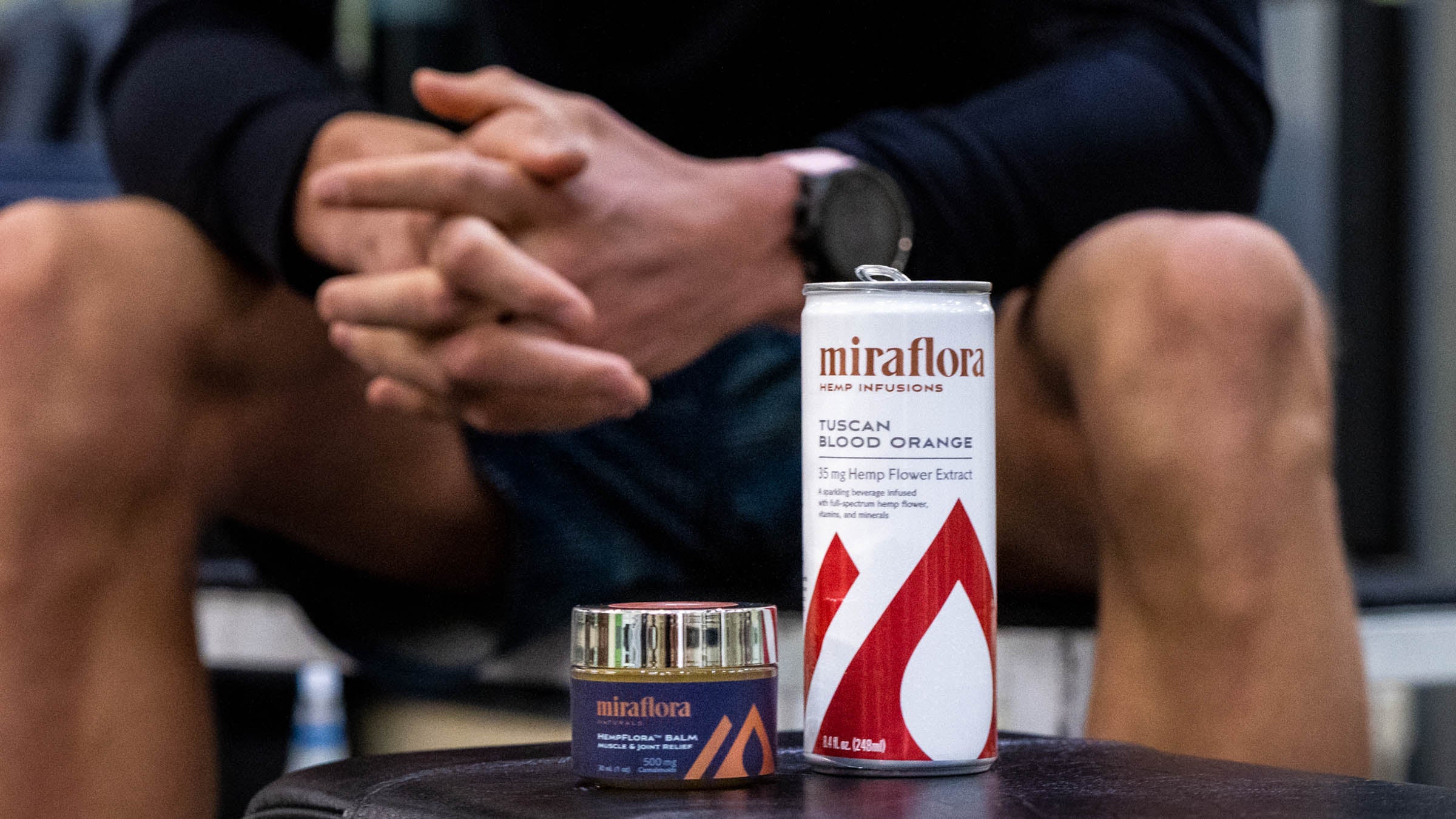 Miraflora drink and muscle balm on bench at gym