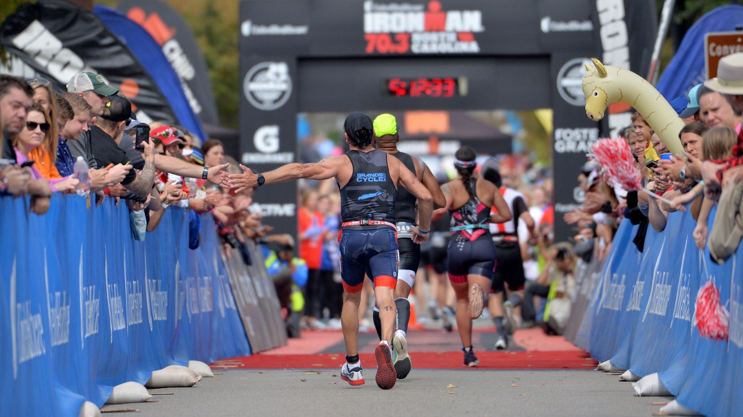 An athlete runs to the finish at Ironman 70.3 North Carolina.