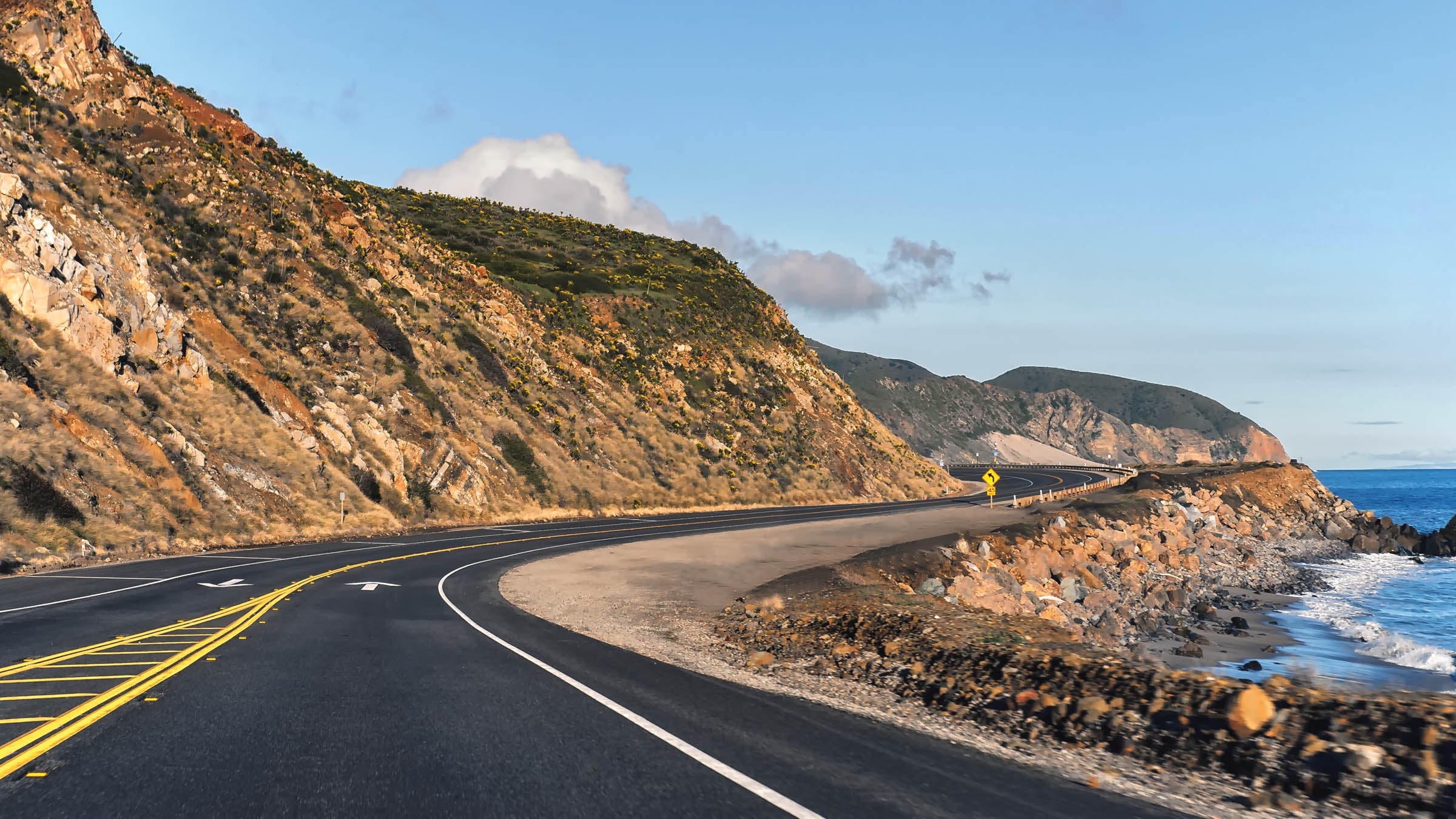 Empty Pacific Coast Highway running parallel to the California coastline