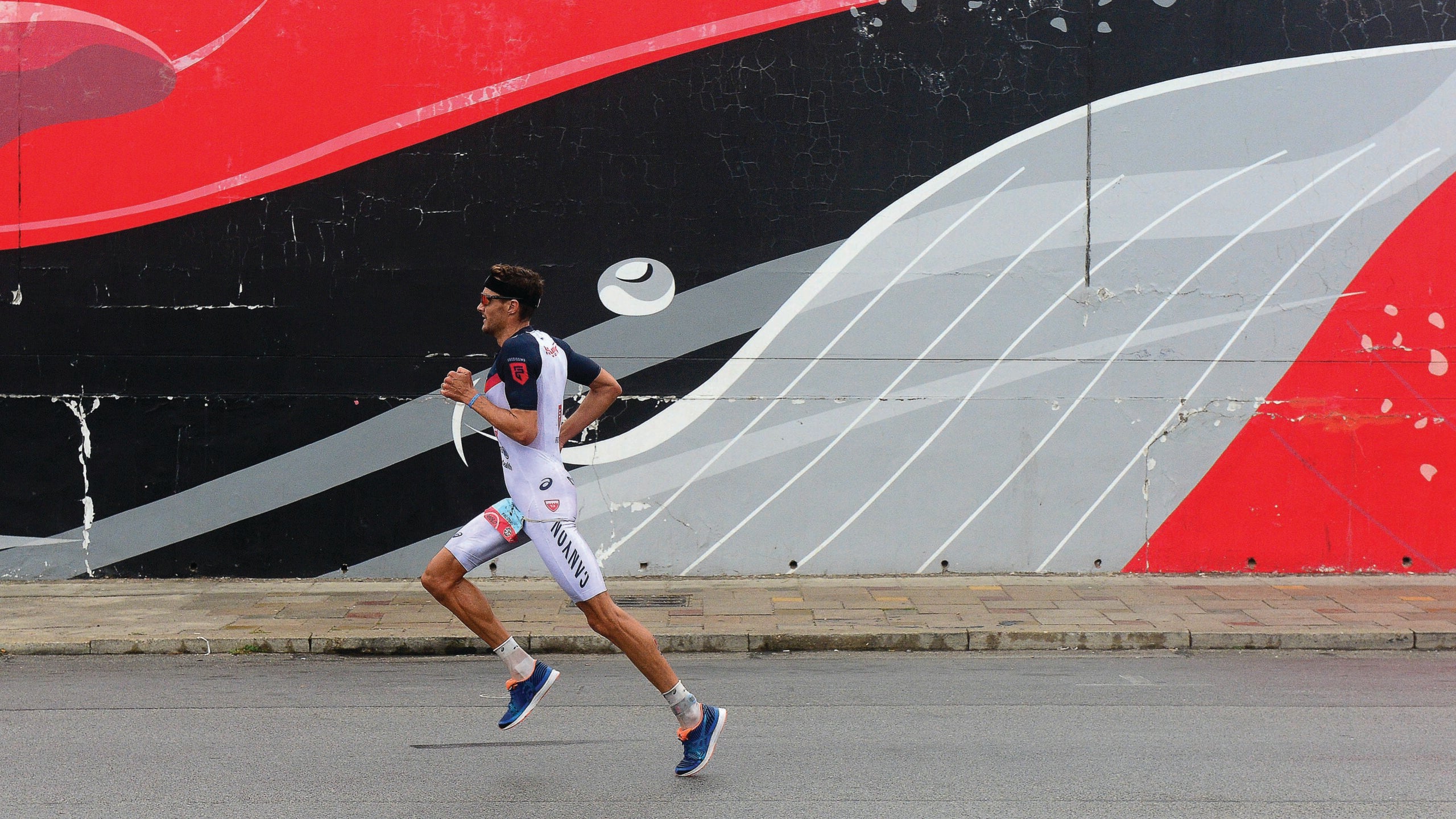 PORT ELIZABETH - SEPTEMBER 2:  Jan Frodeno of Germany runs past a mural of a whale during the Isuzu IRONMAN 70.3 World Championship Men in Port Elizabeth, South Africa on September 2, 2018. Over 4,500 athletes from over 100 countries will be represented in this years 70.3 World Championship. (Photo by Donald Miralle/Getty Images for IRONMAN).