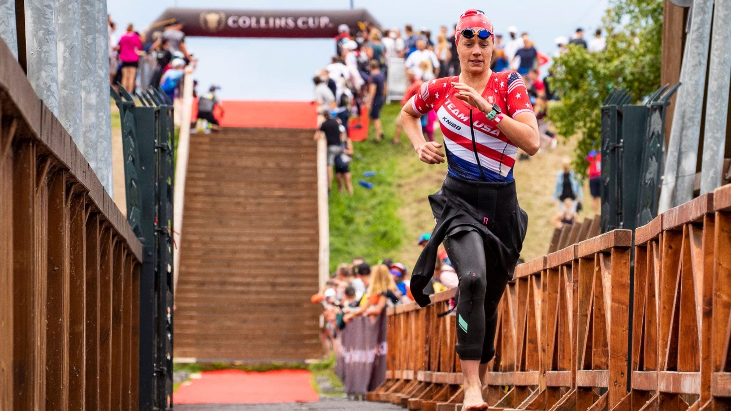 Taylor Knibb, a female triathlete, runs through the swim exit at the Collins Cup.