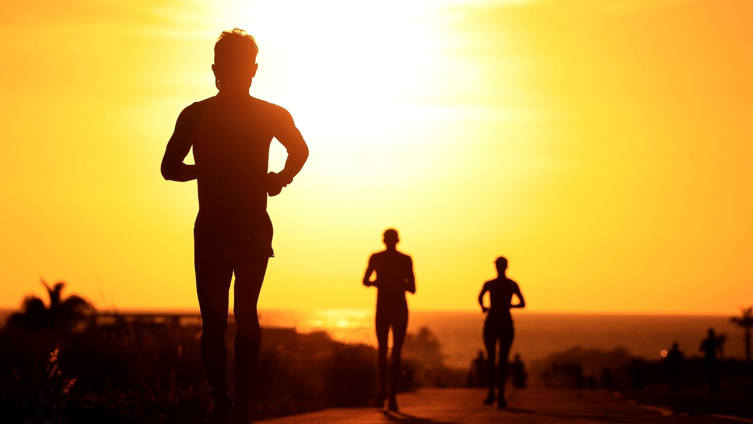 Runners compete as the sun sets during the Ironman World Championships on October 12, 2019 in Kailua Kona, Hawaii.