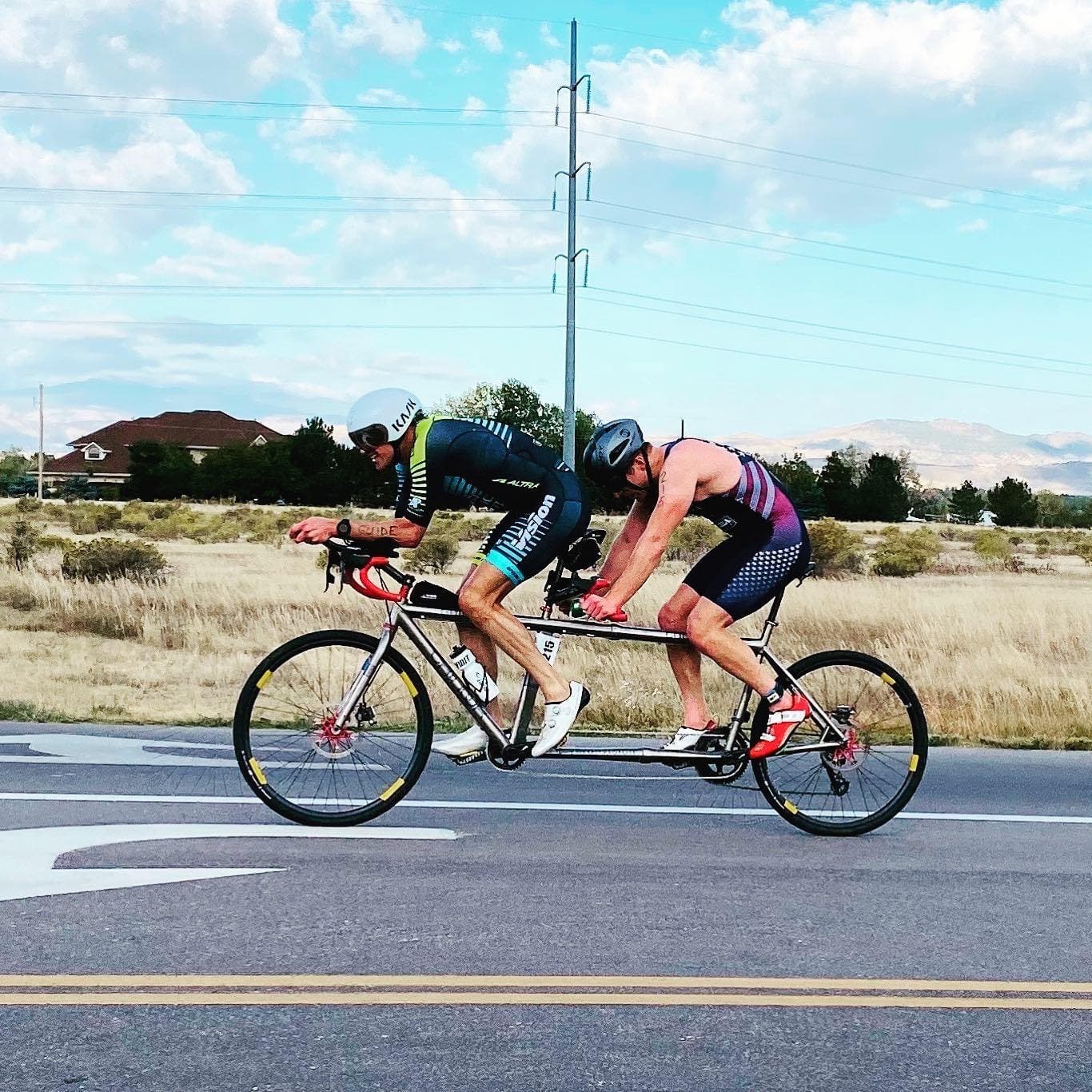 Two men ride a tandem bike during a triathlon.