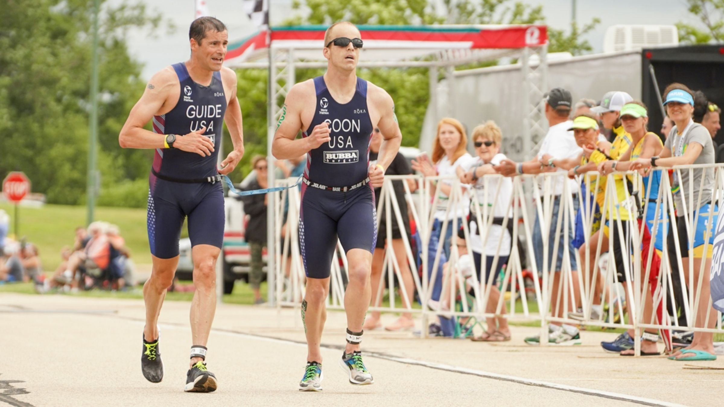 A blind triathlete runs while tethered to his sighted guide.