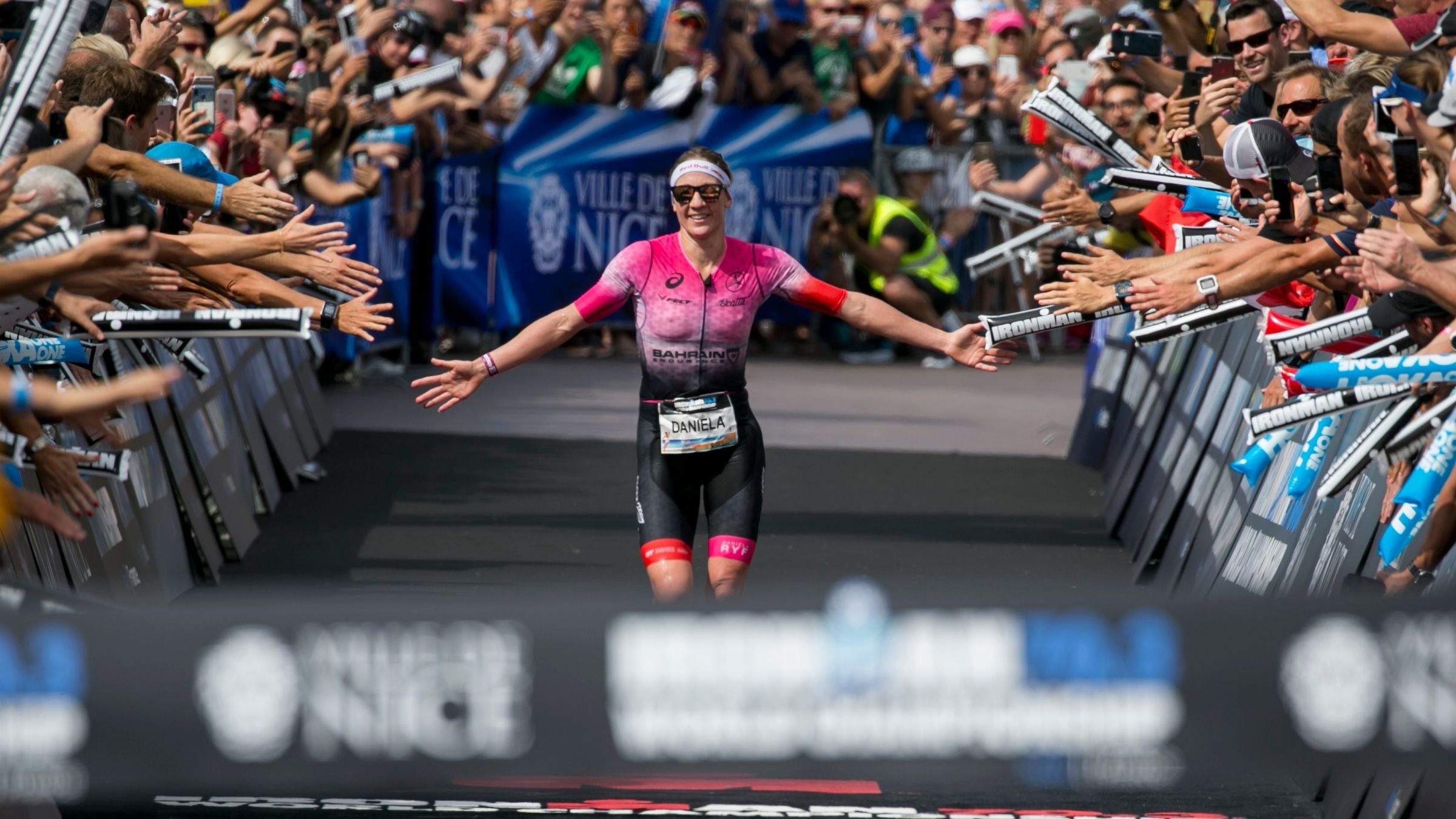 Daniela Ryf gives out high-fives as she crosses the finish line at the 2019 Ironman 70.3 World Championship