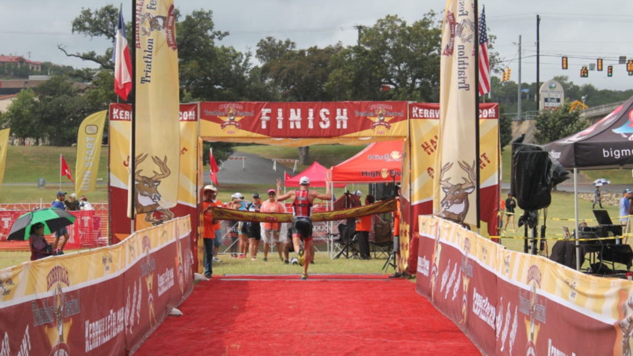 A triathlete crosses the finish line at the Kerrville Triathlon Festival