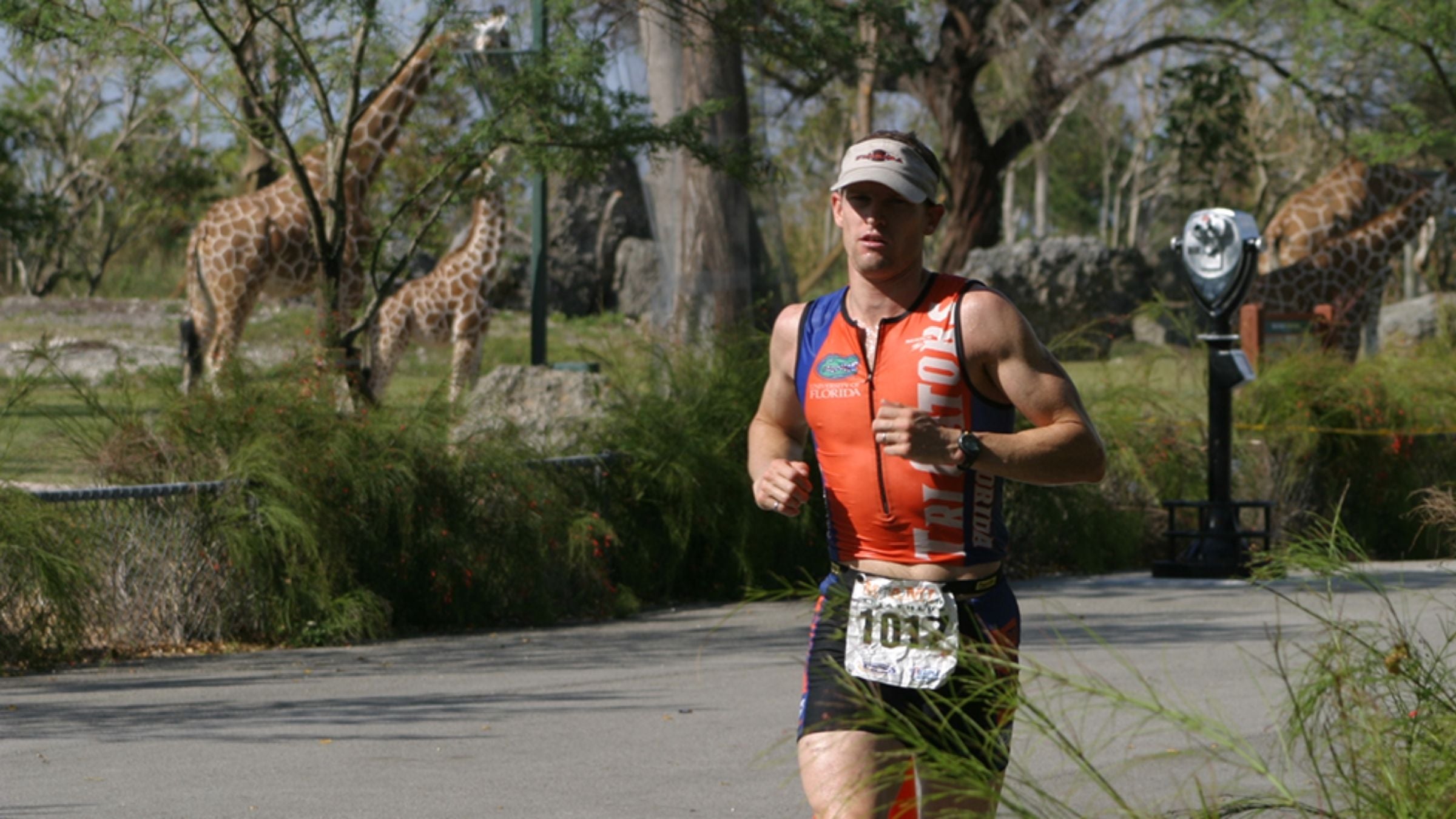 A man runs through the giraffe habitat at the zoo during the Miami Man triathlon.