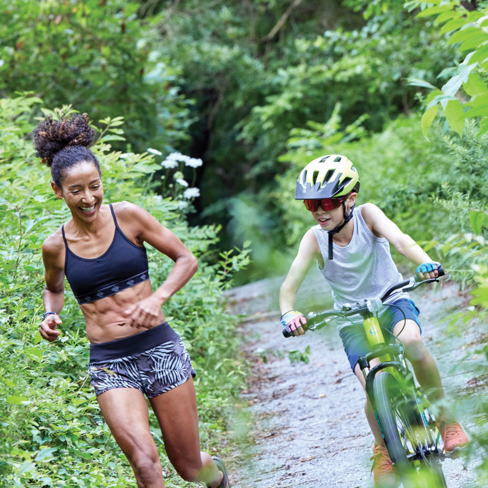 Sin Quee running next to a boy on a bike