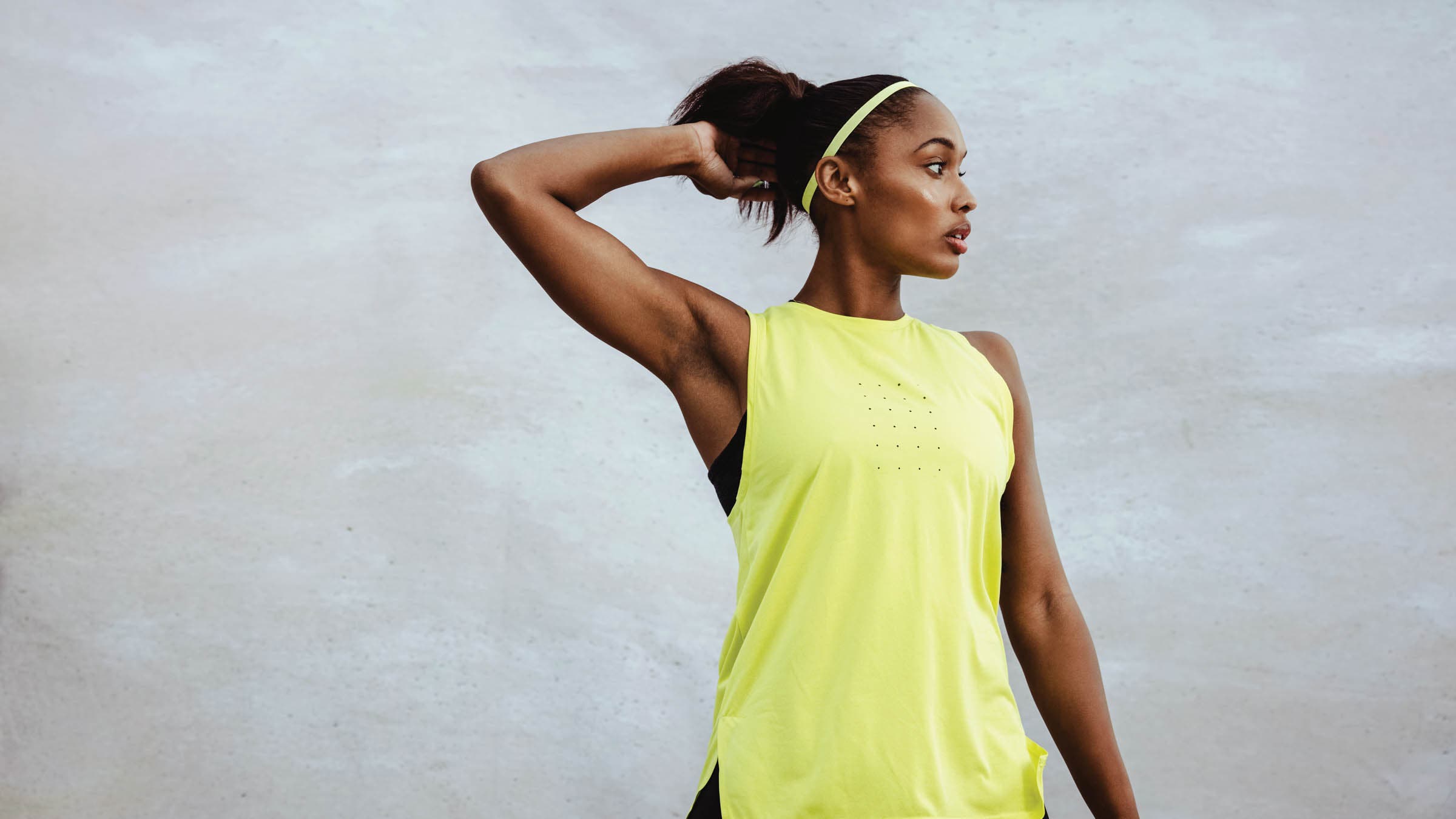 Woman posing in yellow athletic shirt