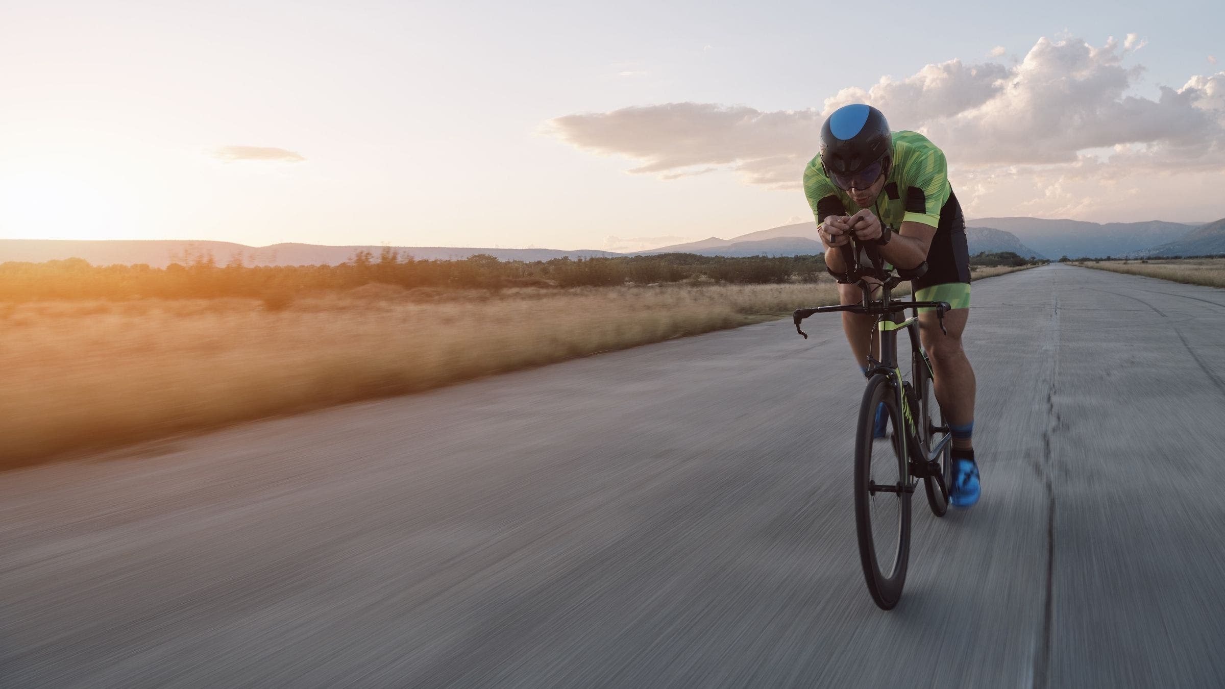 A triathlete trains on the bike. He looks confident, because he understands the purpose of his bike workout.
