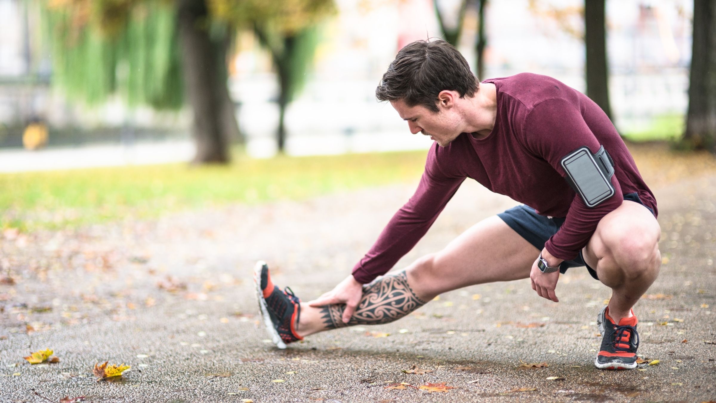 A triathlete completes a calf stretch to prevent tight calves post-workout.