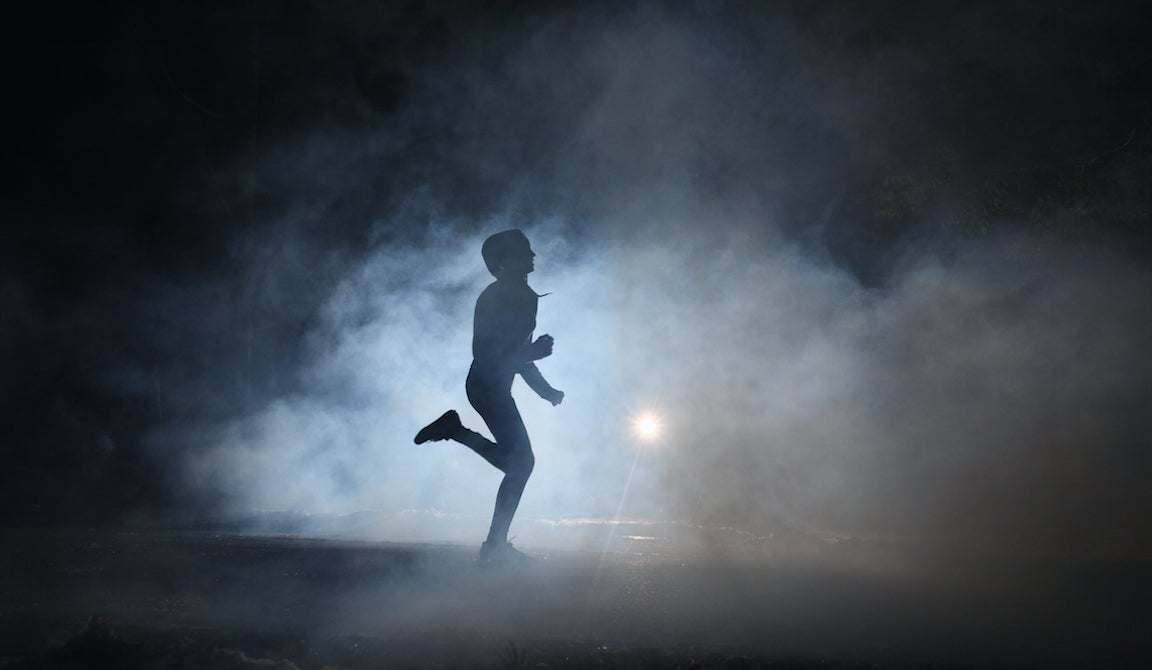 Runner on road in the fog at night