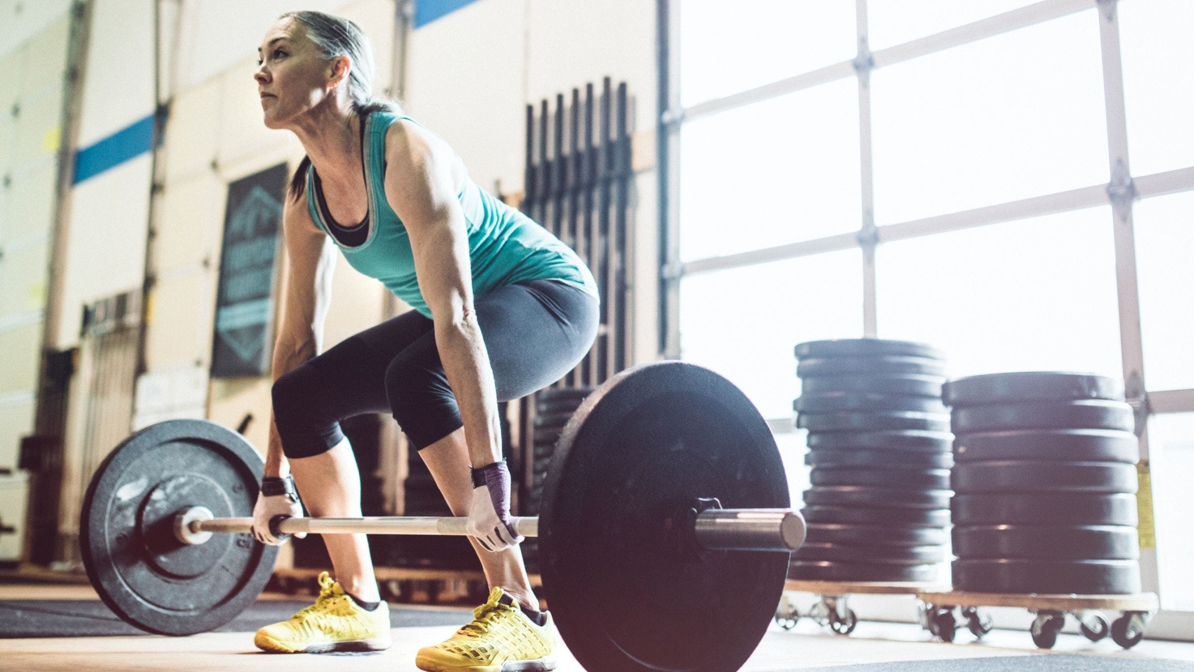 A woman performs a deadlift. It is one of the recommended moves for strength after 50.