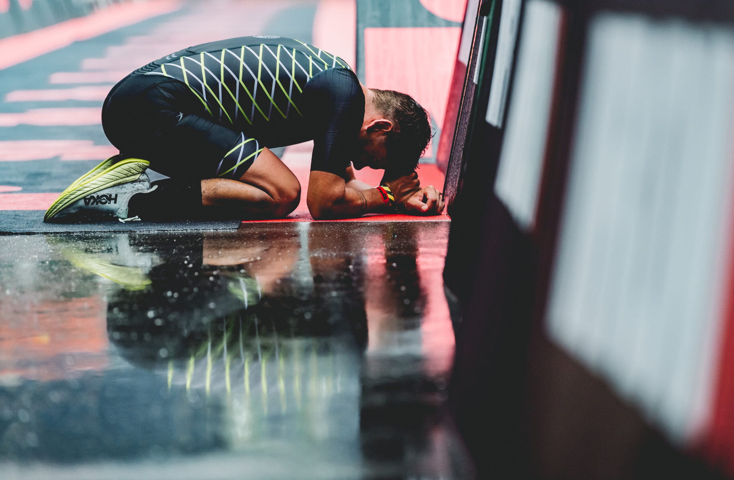 A triathlete collapses his fatigued body after an Ironman.