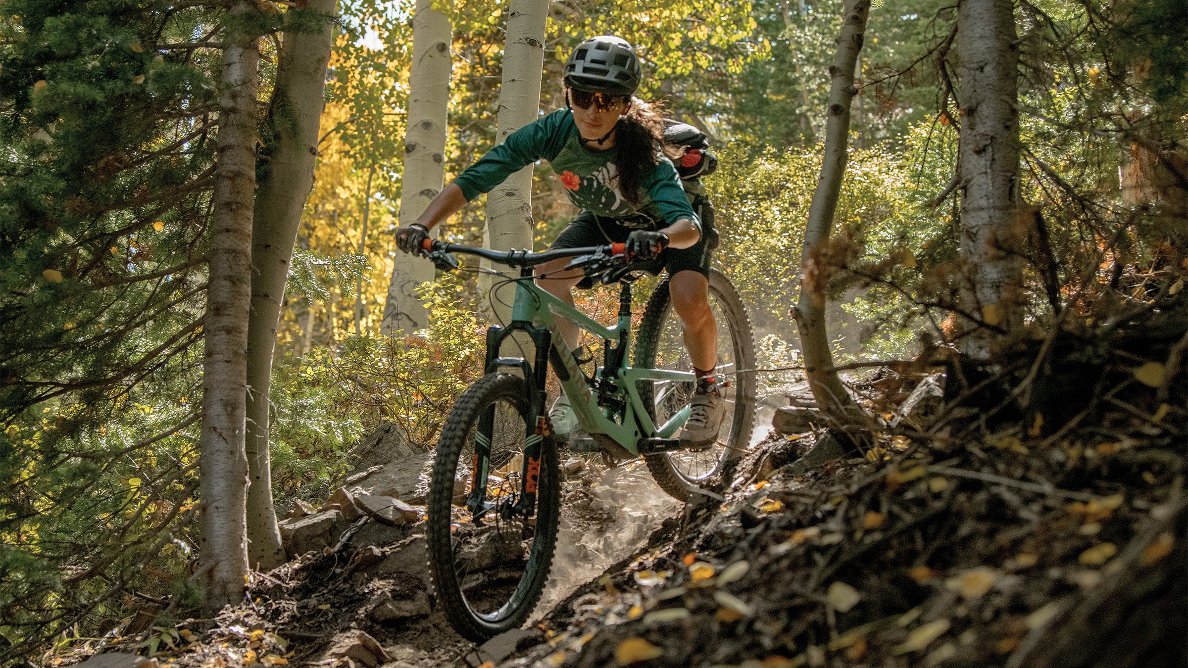 Woman descending a mountain bike track through the trees