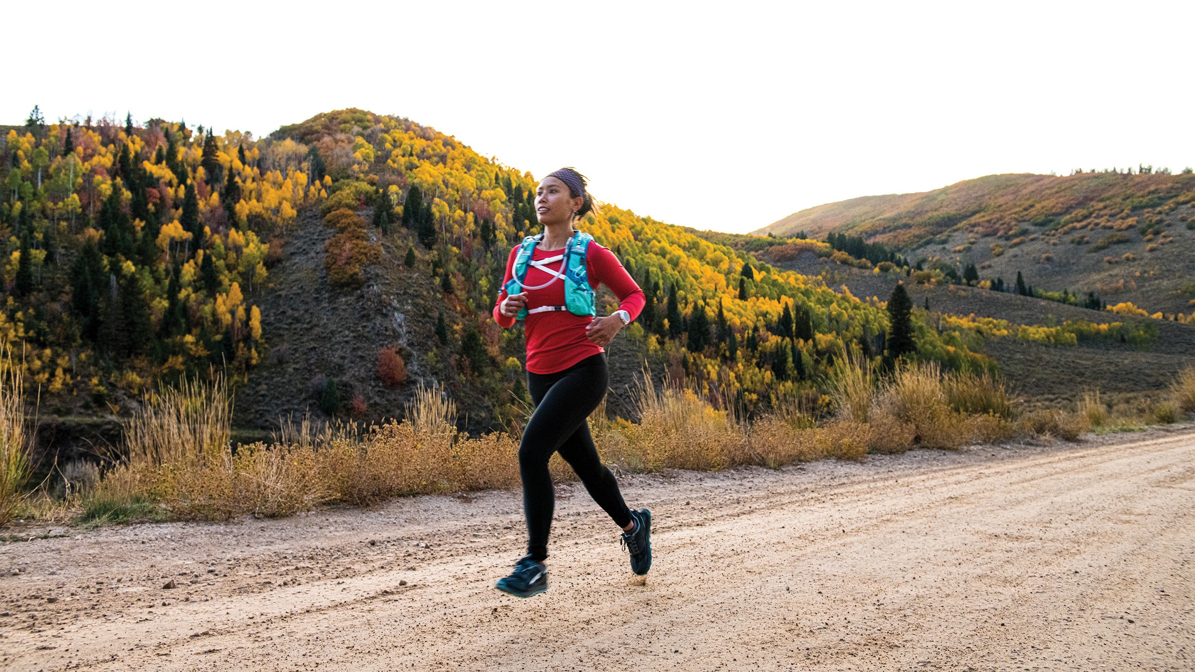 Woman jogging along a dirt road outside Park City in autumn