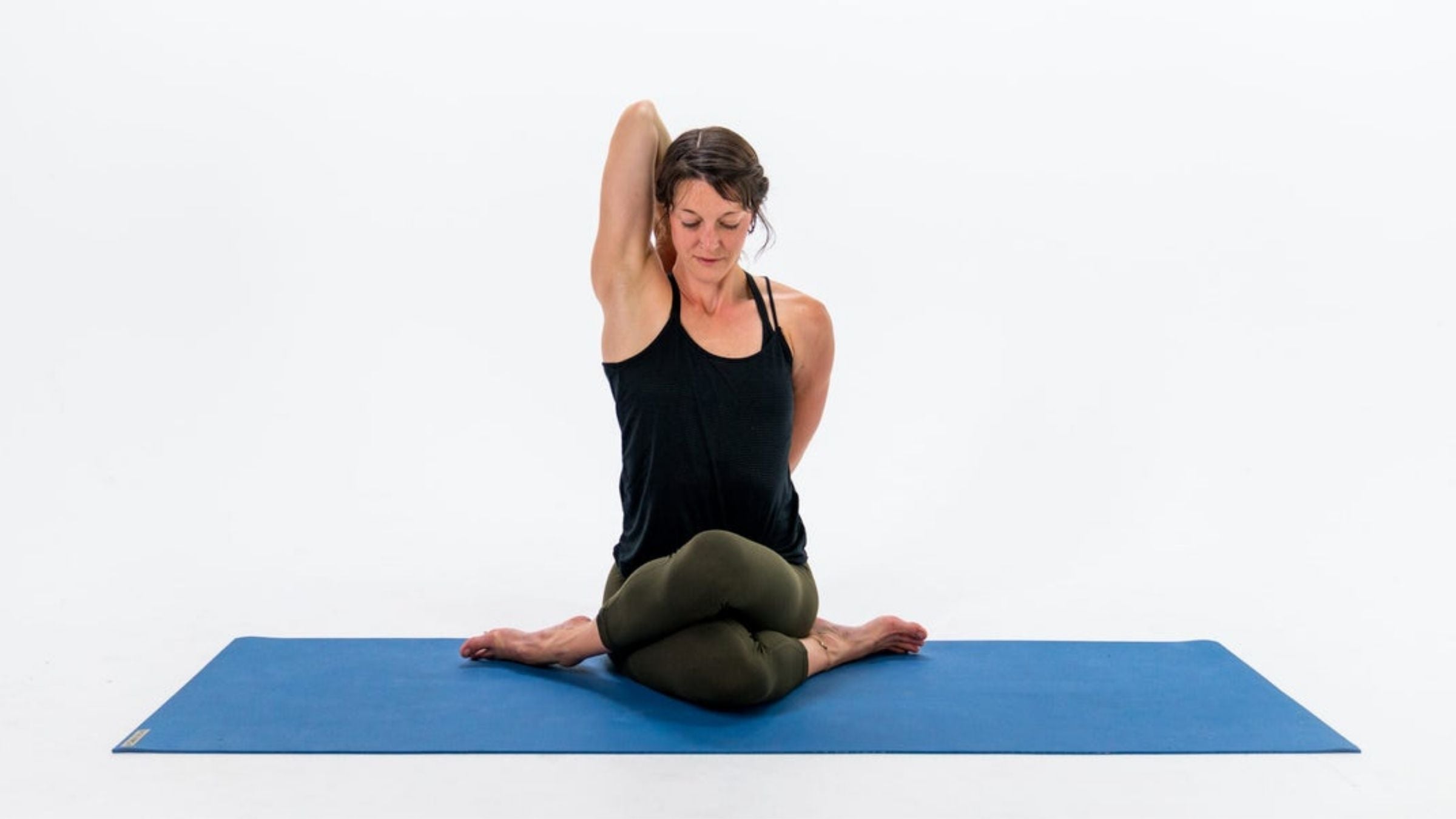 The Holiday Stretch The Yoga Bicycle Female brunette hair, wearing white  vest and grey trousers, lying on her back on pink Stock Photo - Alamy