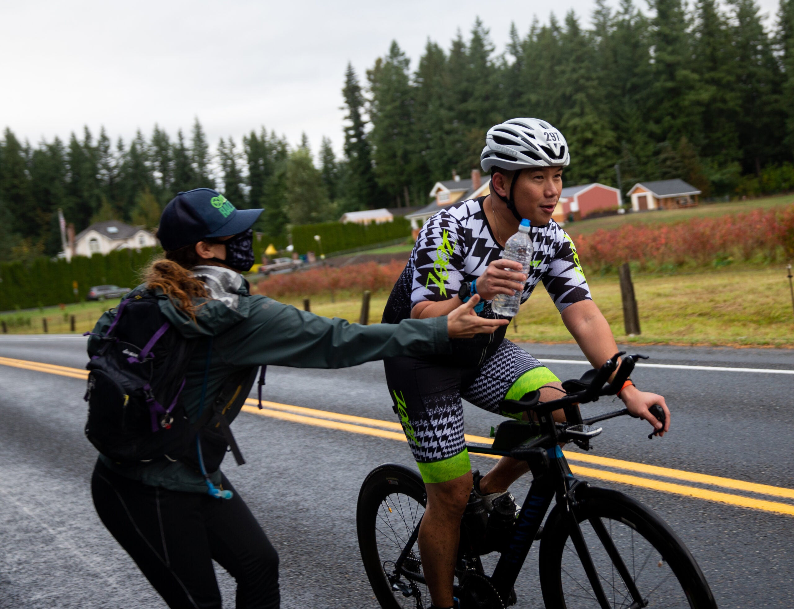 An athlete takes a water bottle on the bike. Hydration is a critical part of a 70.3 nutrition plan.
