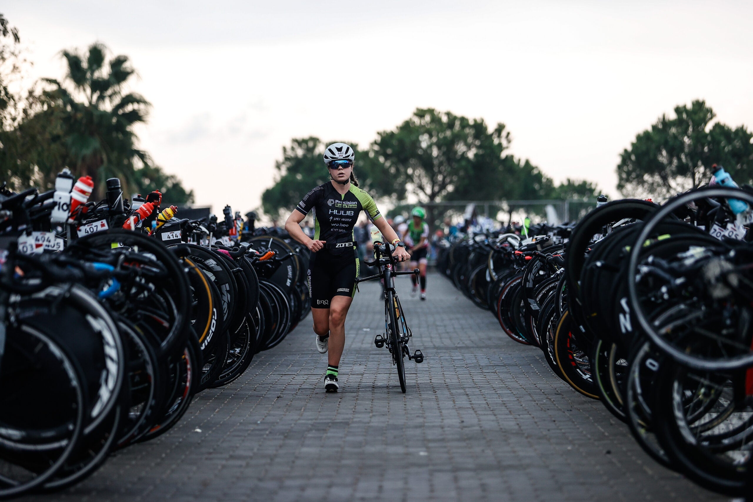 A triathlete makes her way through the transition area of a half ironman. Racing a 70.3 requires a lot of gear.