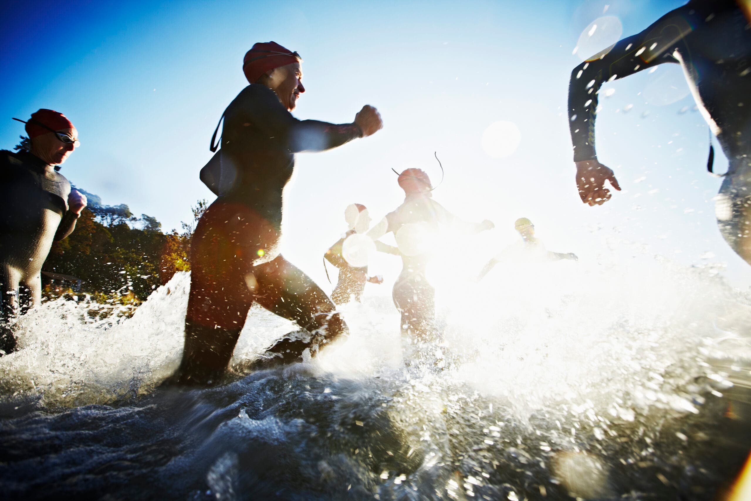 Group of athletes starting their race after training with a couch to triathlon training plan.