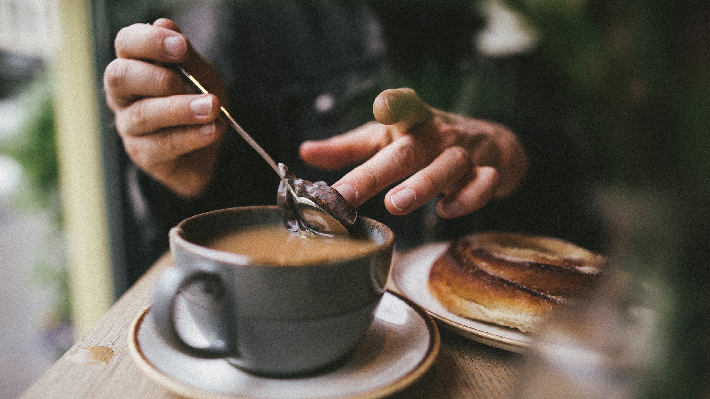 Someone drinks a mug of tea. Many athletes wonder if they should abstain from caffeine before a race.
