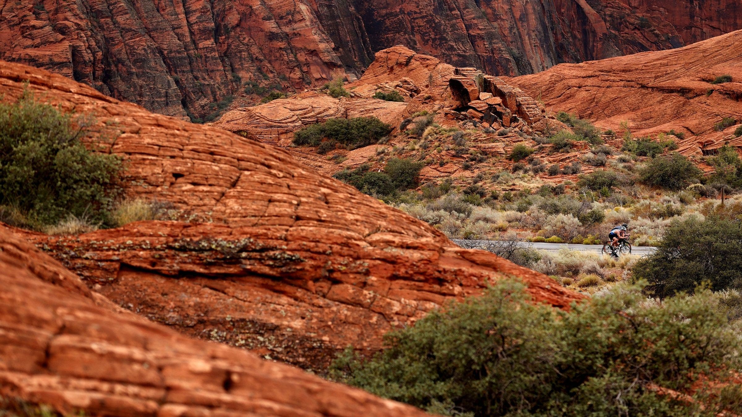 A cyclist makes his way through the red rocks of the Ironman St. George course.