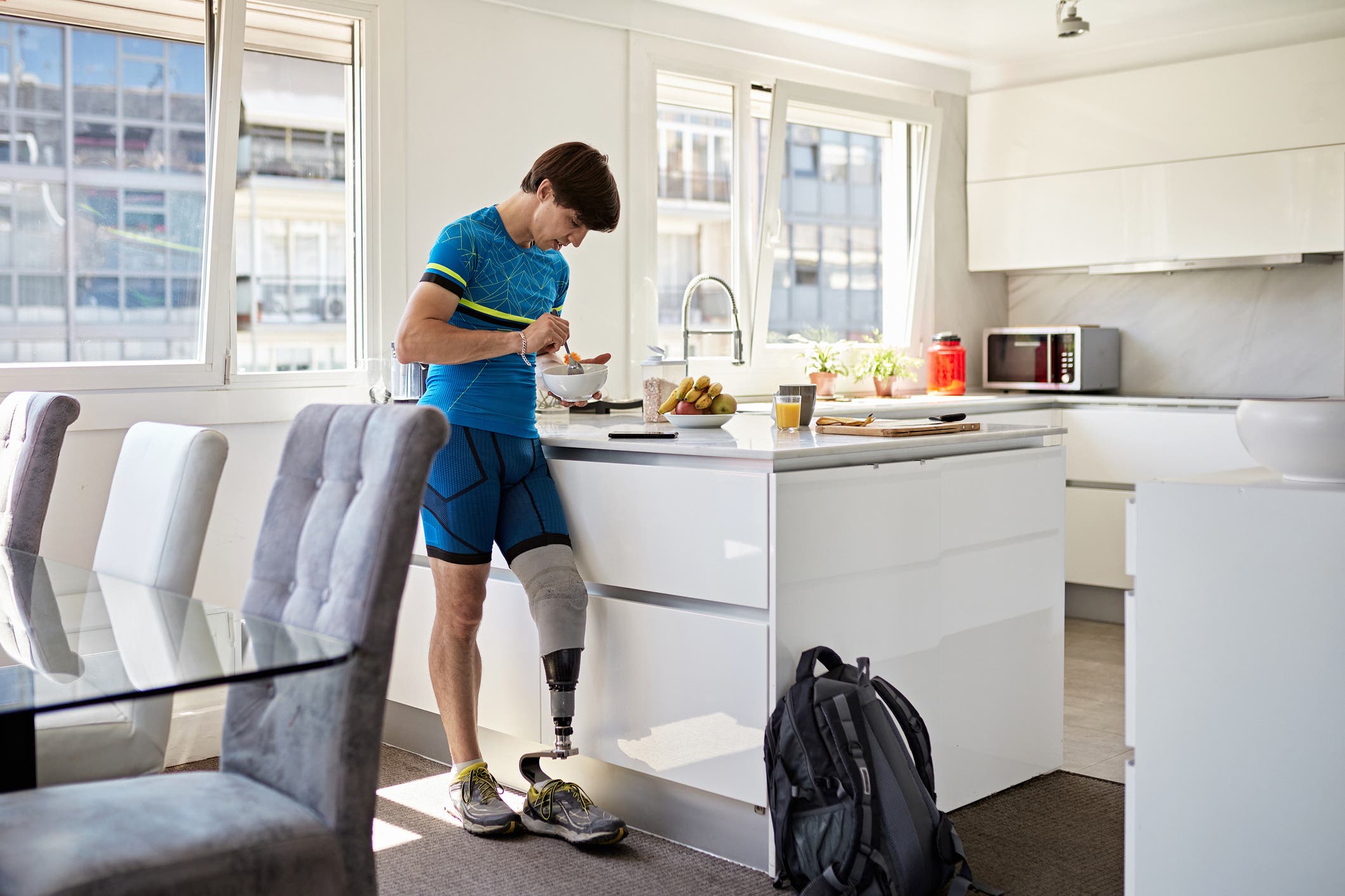 A man eats an alkaline diet for athletes in his kitchen.