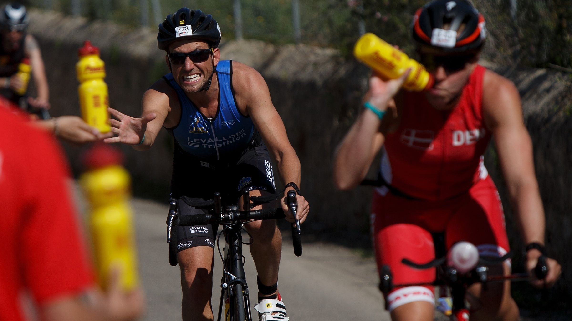A triathlete reaches for a bottle of electrolyte drink.
