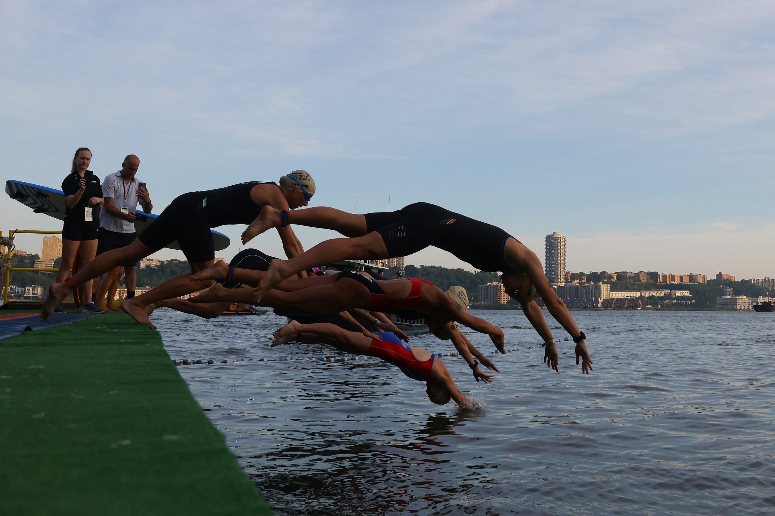 Athletes dive in to start their triathlon race after moving up from sprint to Olympic distance.