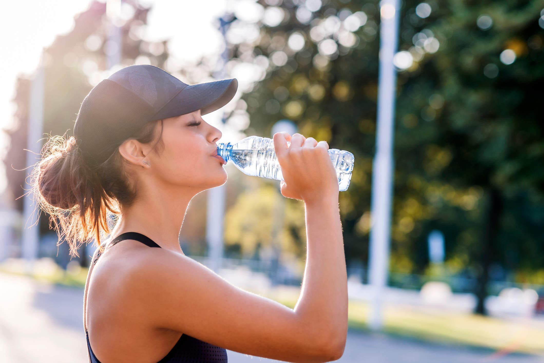 A woman drinks water to prevent hyponatremia during a race