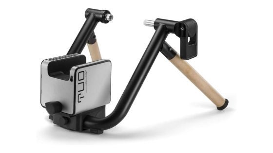 A black bar with wooden feet and a silver box for the Elite Tuo smart trainer, one of the best indoor bike trainers for triathletes
