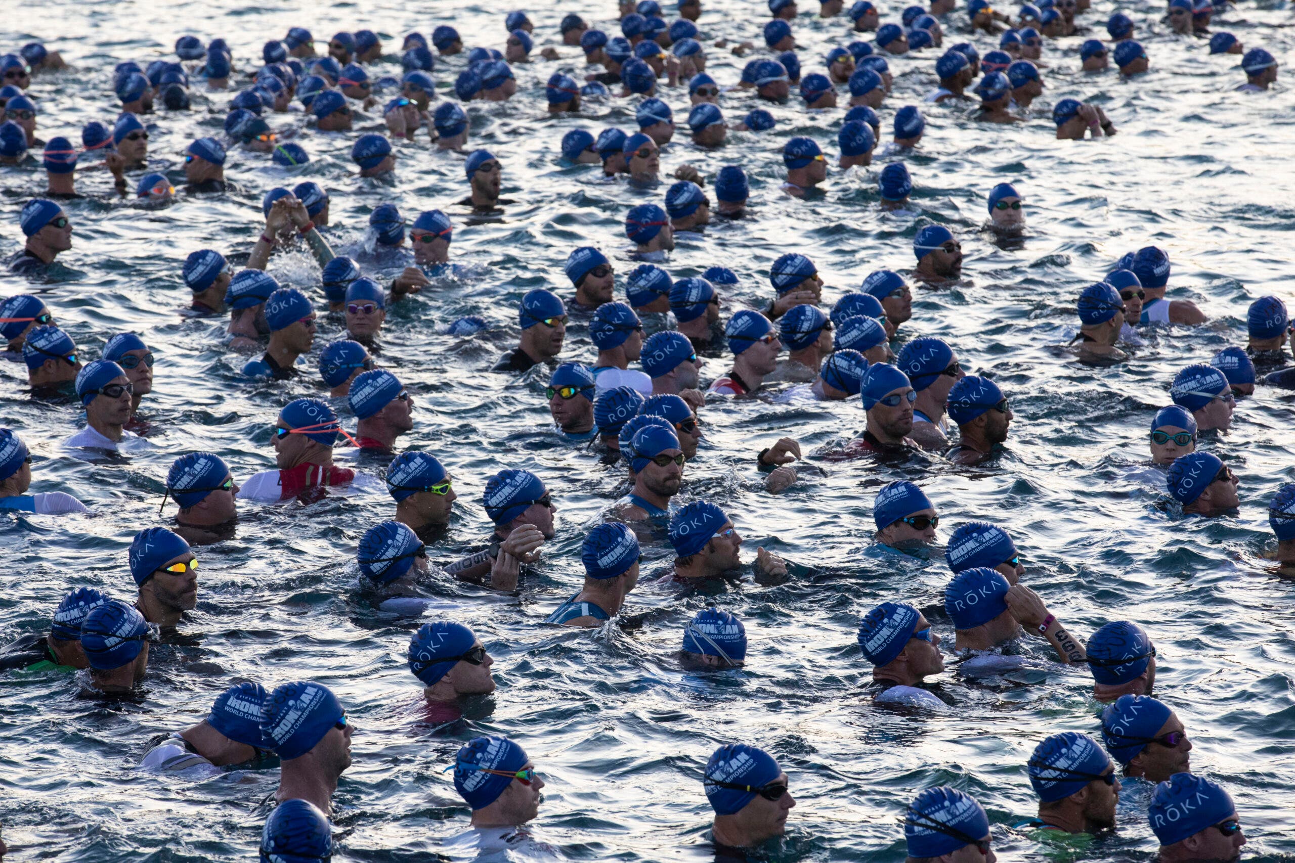 Athletes are in the water preparing to start a triathlon after meticulously planning their season using the triathlon planning worksheet.