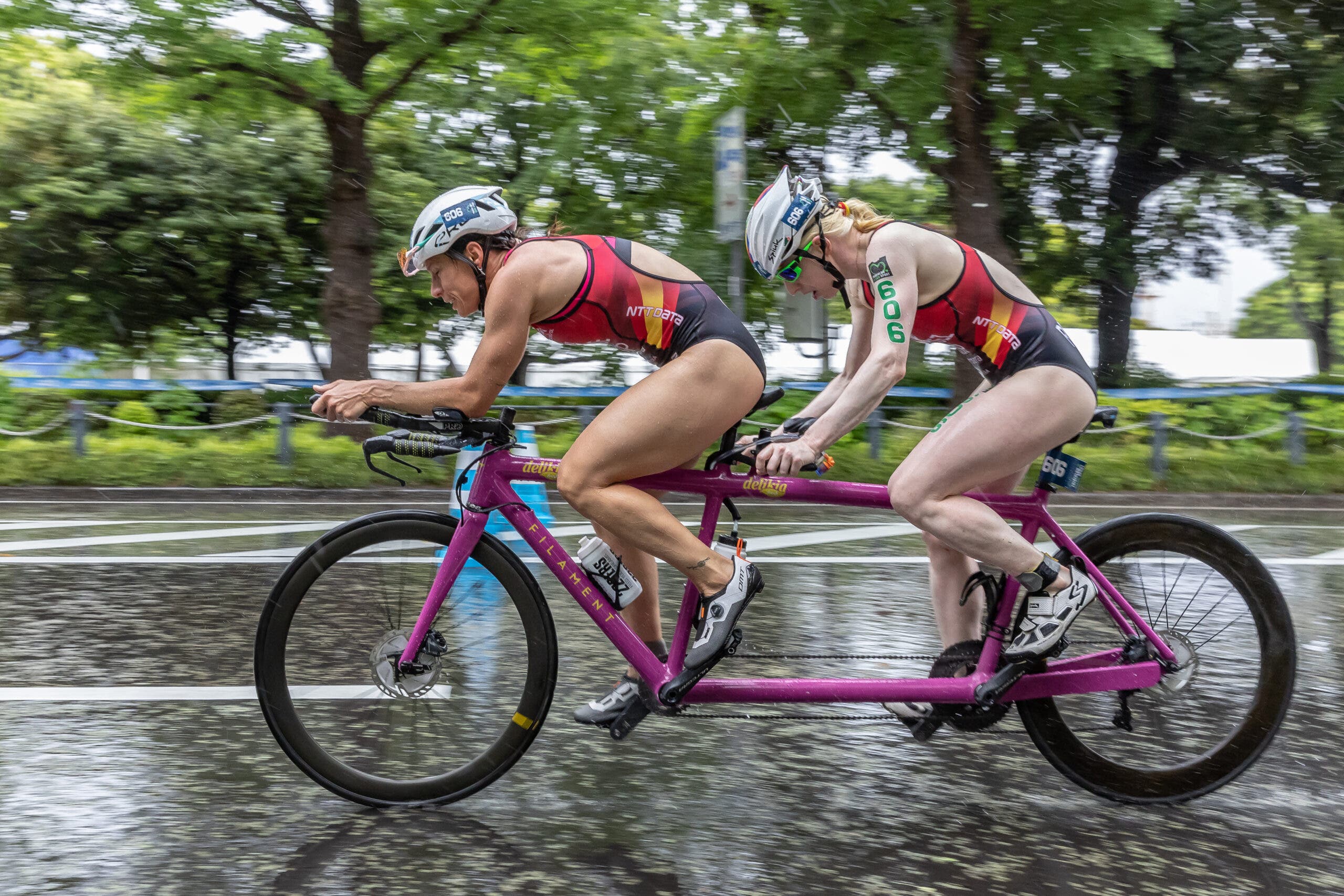 Susana Rodriguez, a triathlete with visual impairment, rides a tandem bike with a guide during a triathlon race.