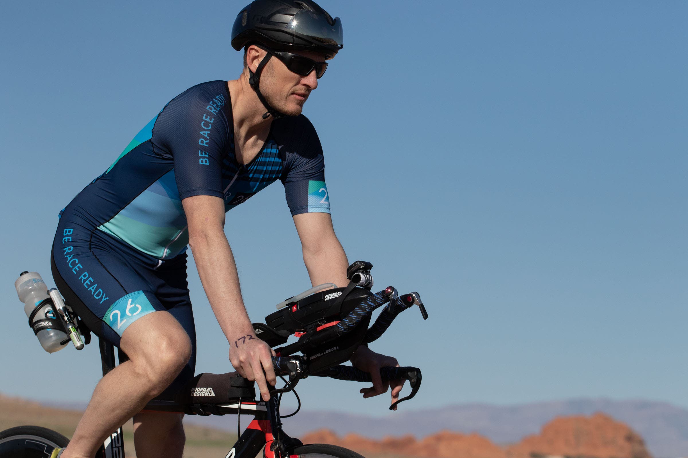 A triathlete rides a bike during triathlon racing after planning their season using the triathlon season planning worksheet.