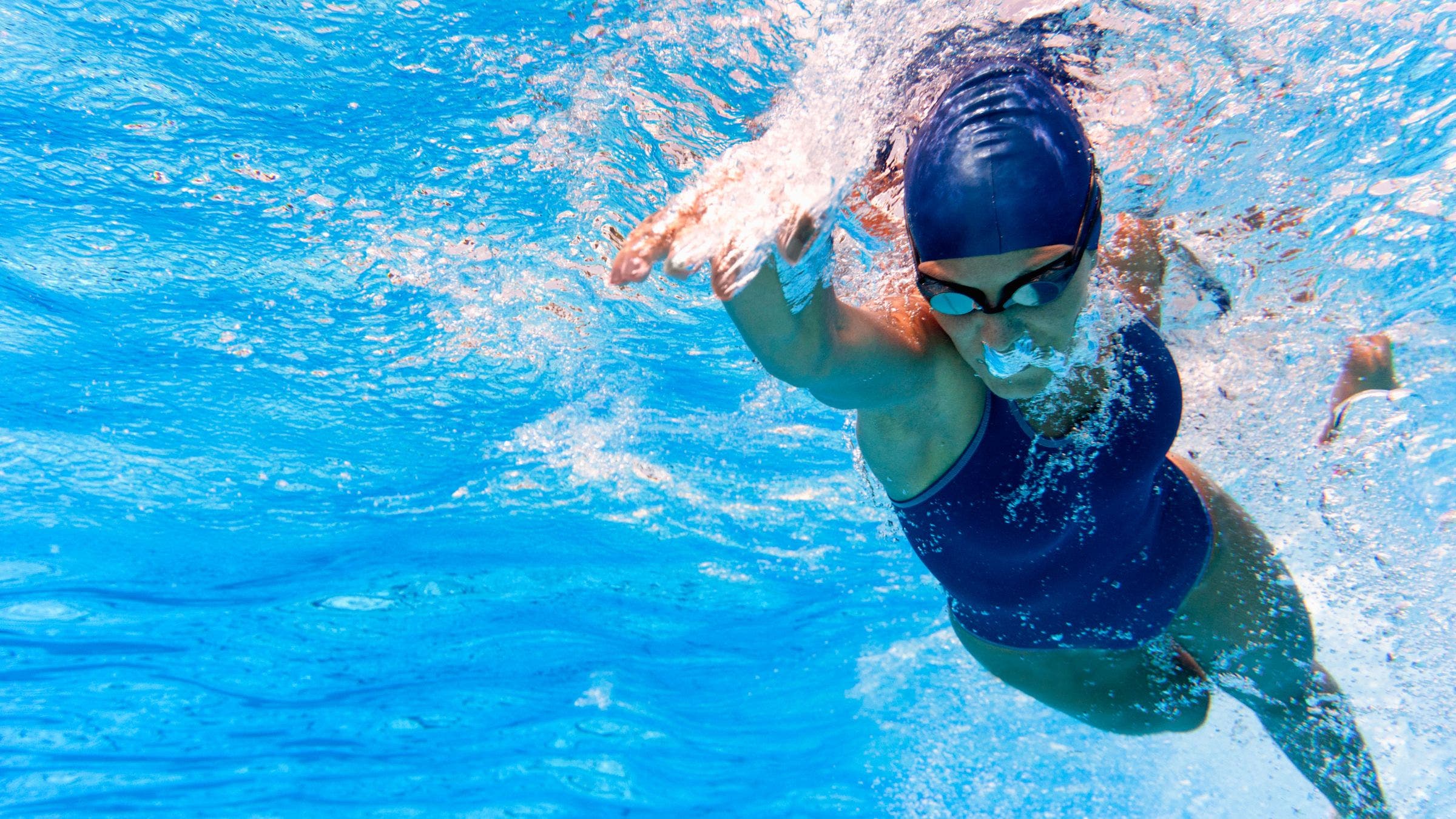 A woman swims laps while wondering How long does it take to get back in swimming shape?