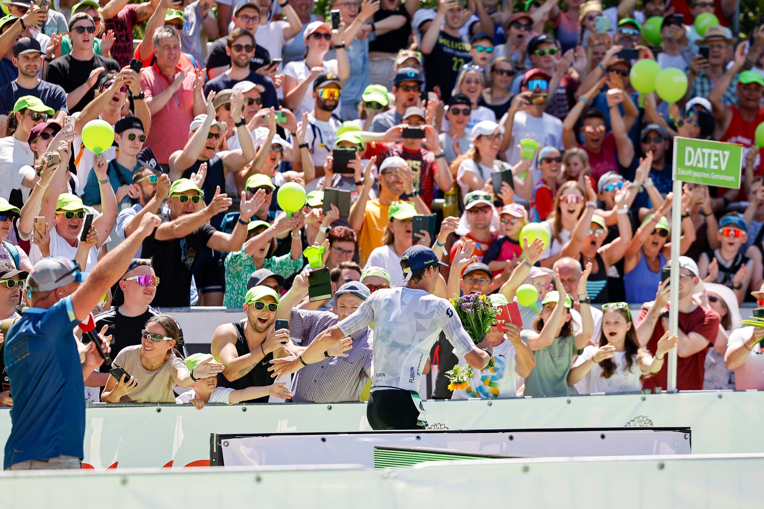 Denmark's Magnus Ditlev runs past fans in the stadium on his way to breaking the tape at Challenge Roth 2023.