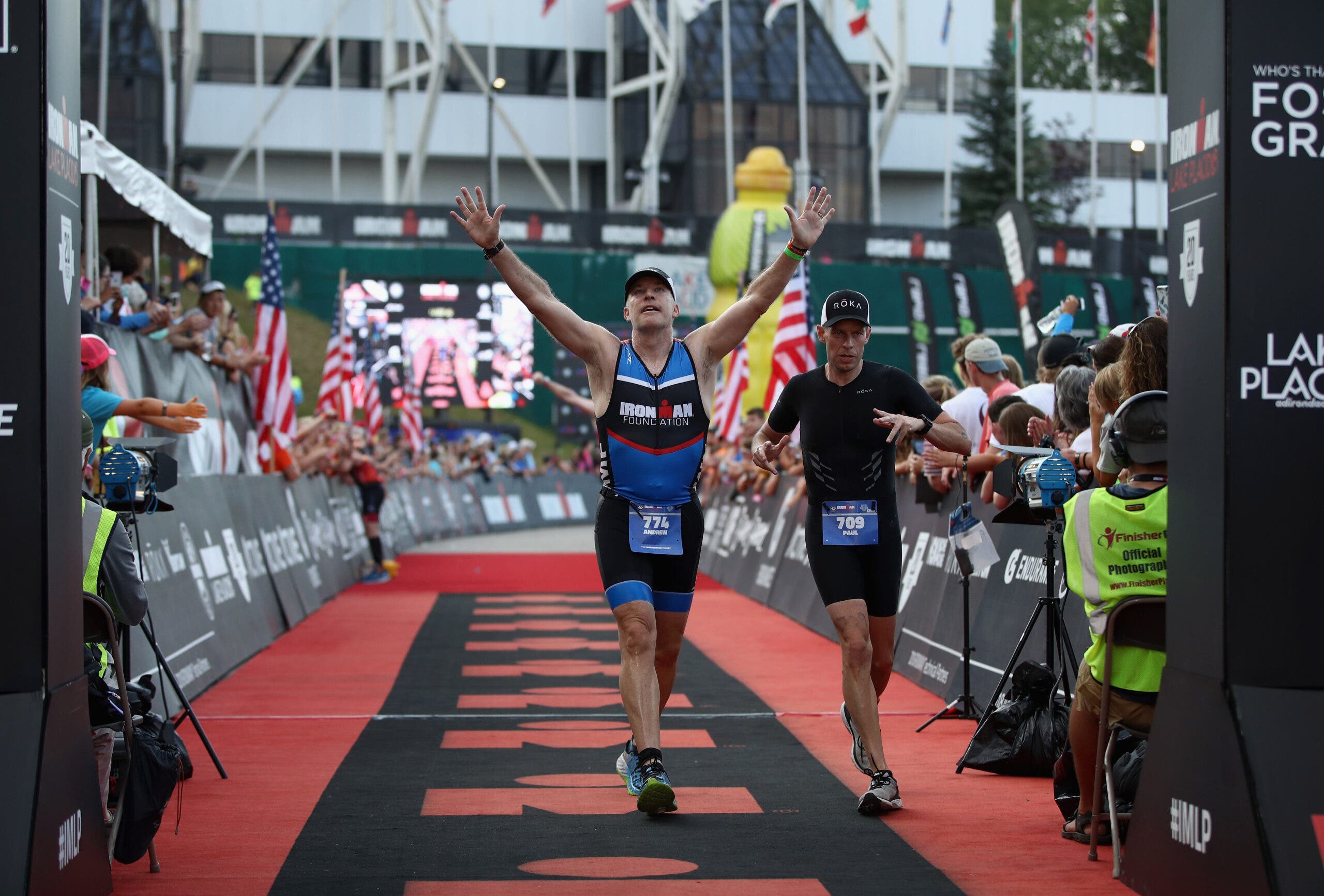 Ironman CEO Andrew Messick crosses the finish line at Ironman Lake Placid 2018.