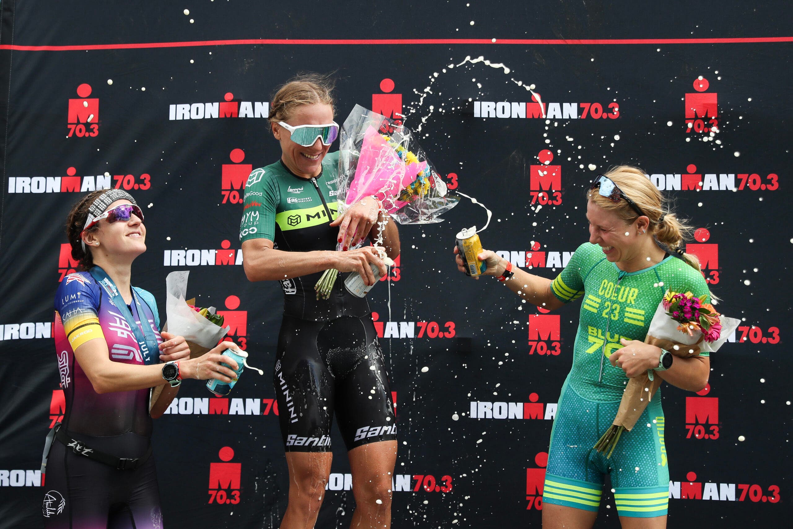 Ironman 70.3 Maine winner Giorgia Priarone of Italy (center), second place finisher Amy Cymerman (right), and third place finisher Nicole Falcaro (left) celebrate on the podium.