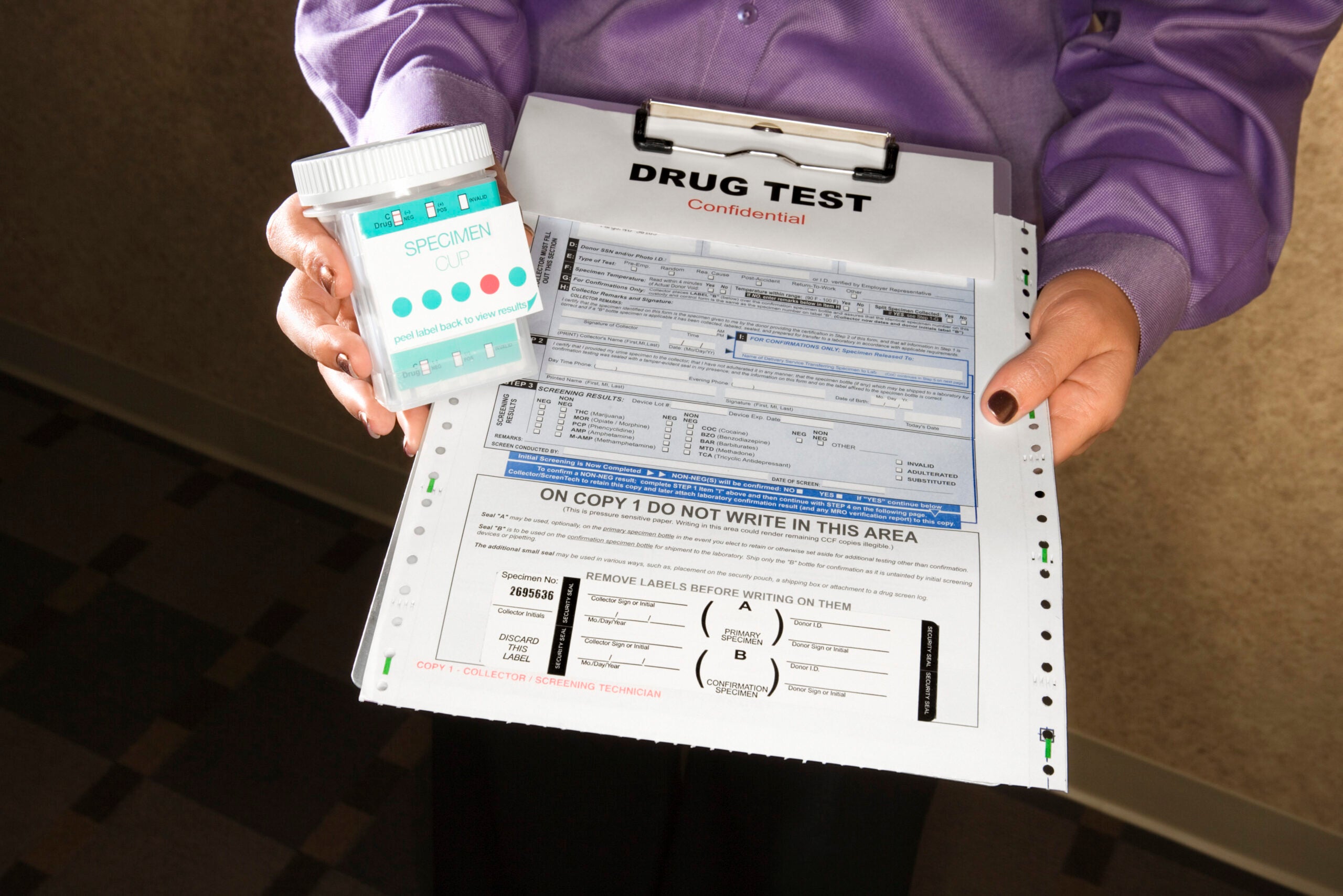 A woman holds a clipboard with forms for drug testing in triathlon