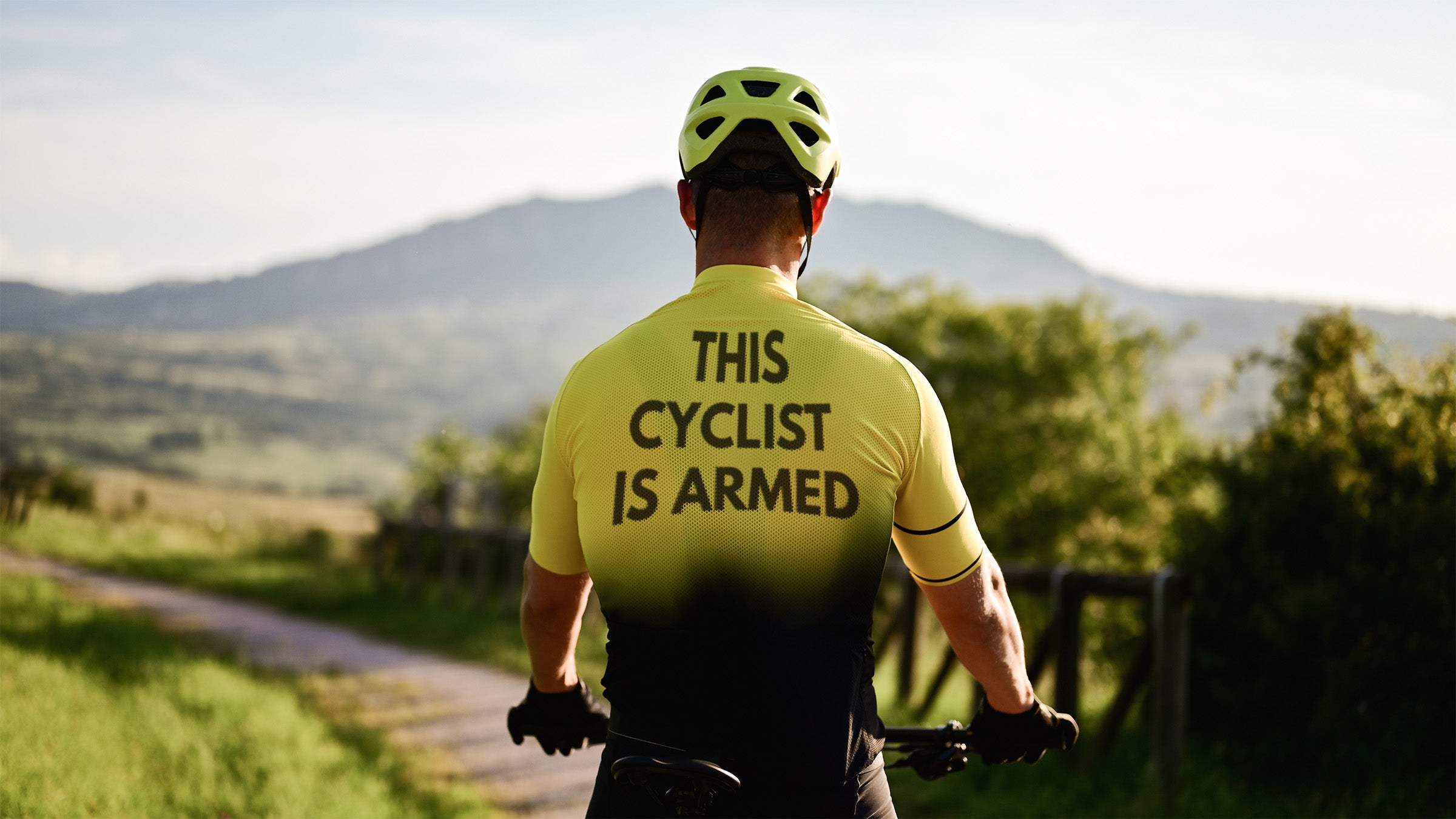 Edited stock image of cyclist with jersey reading "this cyclist is armed"