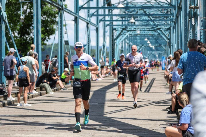 Athletes run across a bridge during Ironman 70.3 Chattanooga.